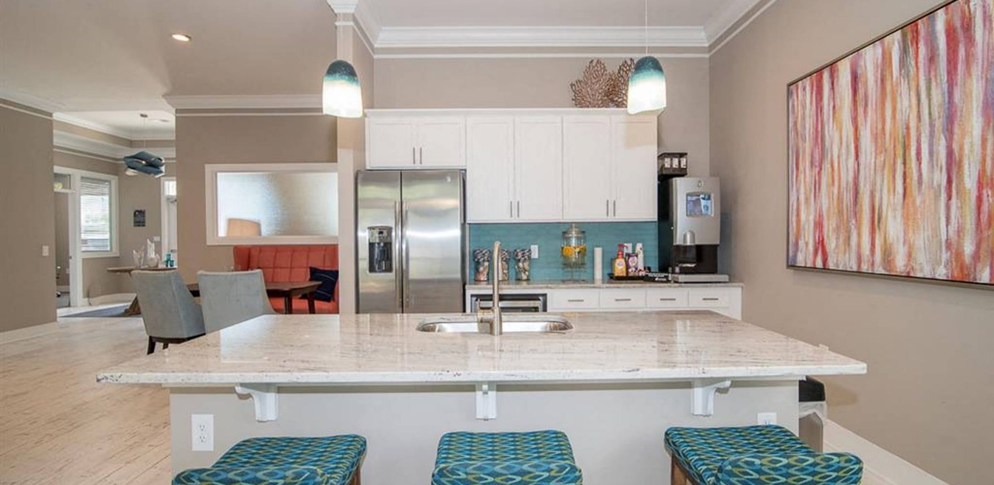 Hawthorne at New Centre resident amenity area with large island with bar stools, stainless steel appliances, and a large sink